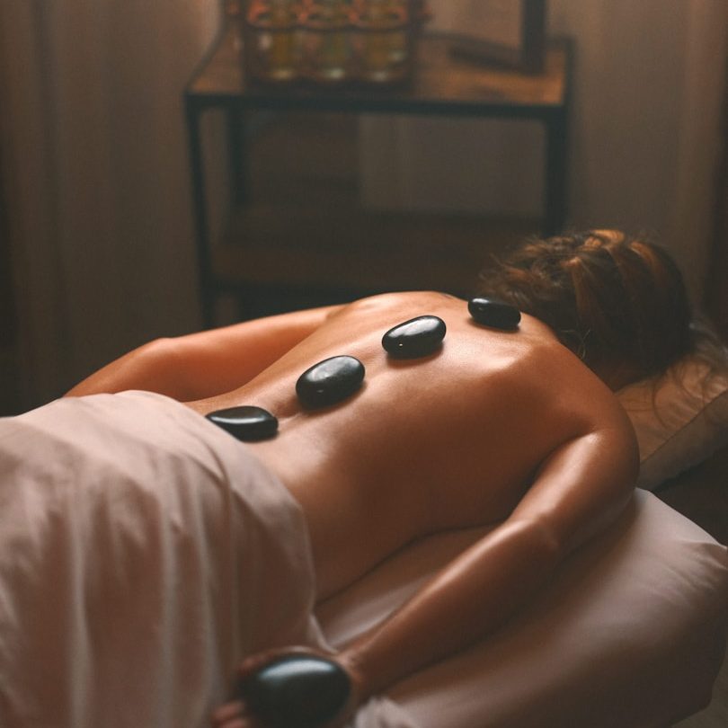 Hot Stone Massage for Deep Relaxation Therapist applying hot stones on a client’s back during a hot stone massage in Wolverhampton